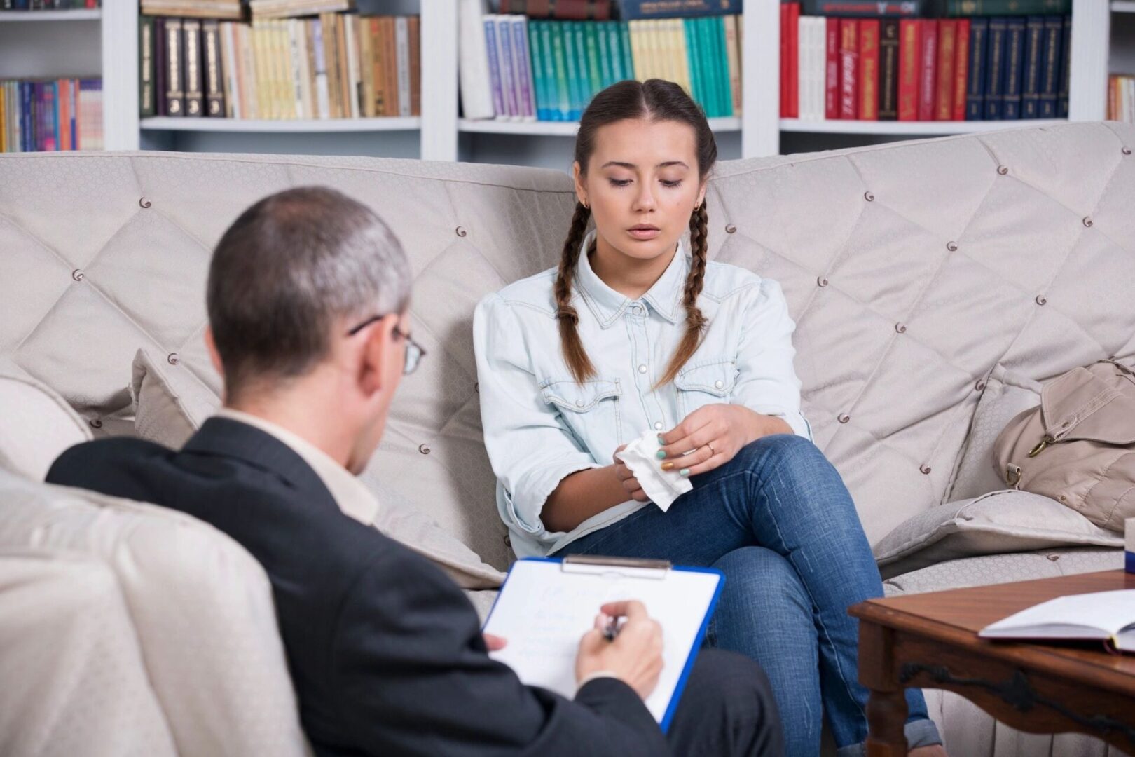 A woman sitting on the couch with an older man.